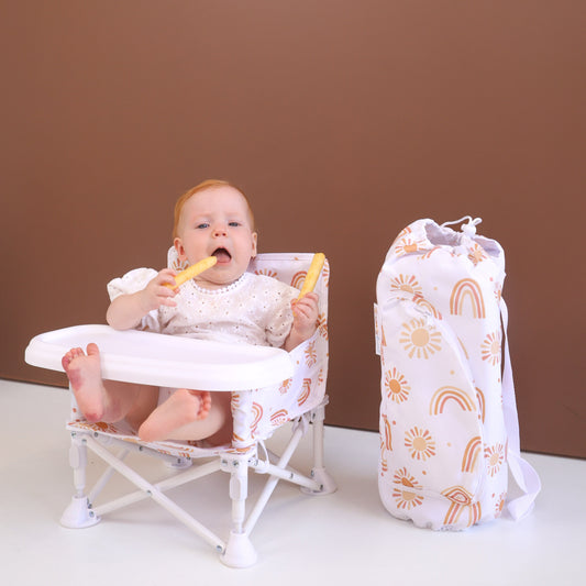 Baby sitting in a high chair with a bag of toys next to them on a brown background