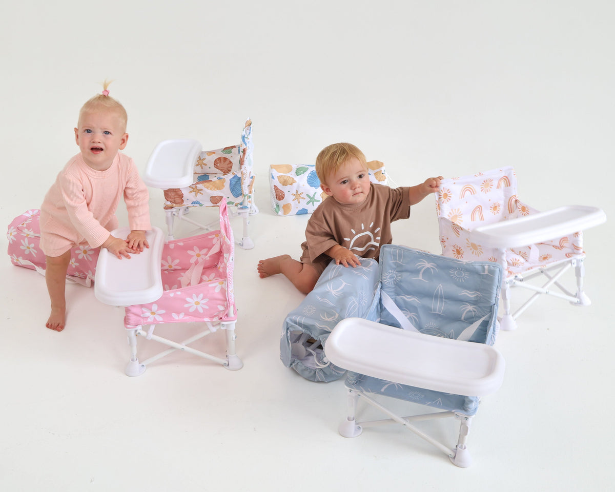 Two children sitting on colorful chairs with a white background